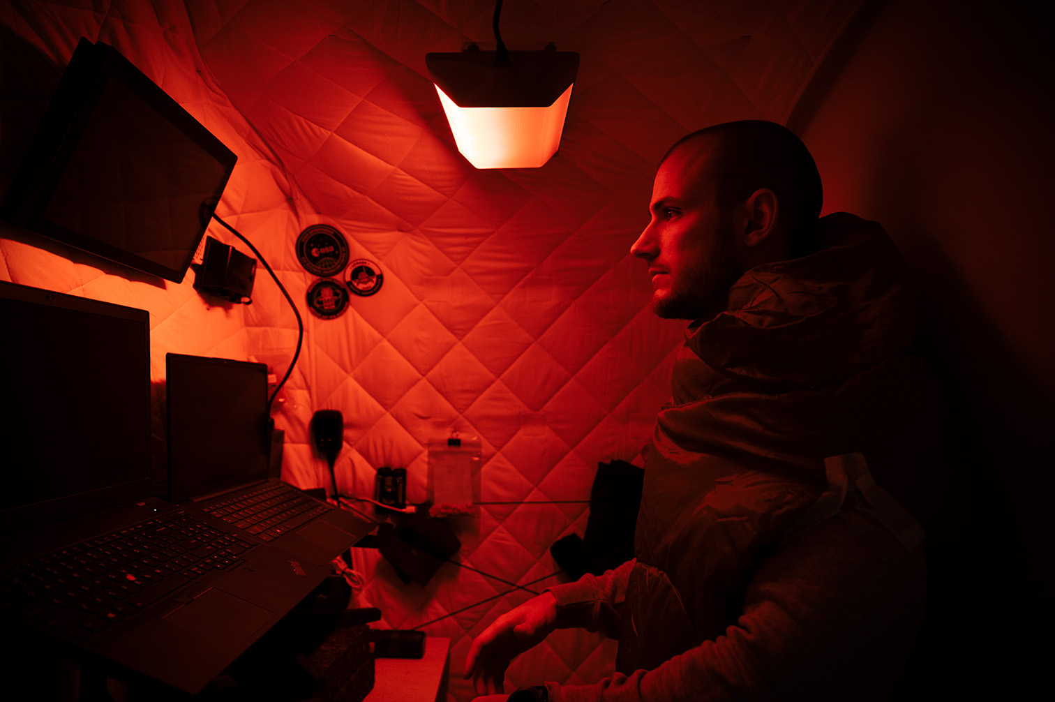 Um homem em uma pequena sala com uma luz circadiana brilhando em vermelho.  
