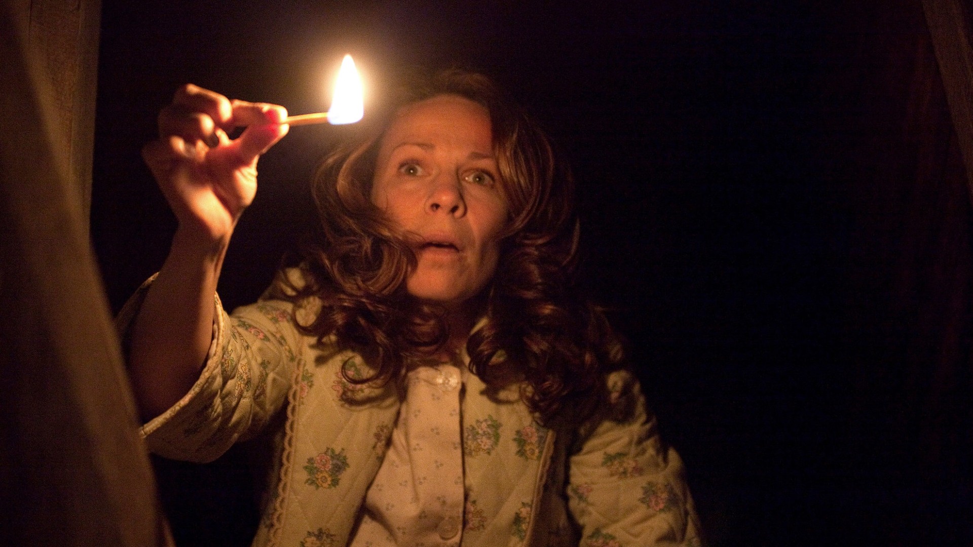 Lili Taylor holds a match up while staring down into a dark basement.