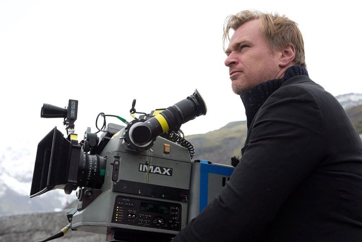 Christopher Nolan com uma câmera de filme.