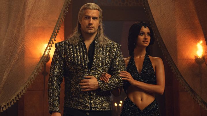 Henry Cavill and Anya Chalotra as Geralt and Yennefer walking into the mages' ball in The Witcher.