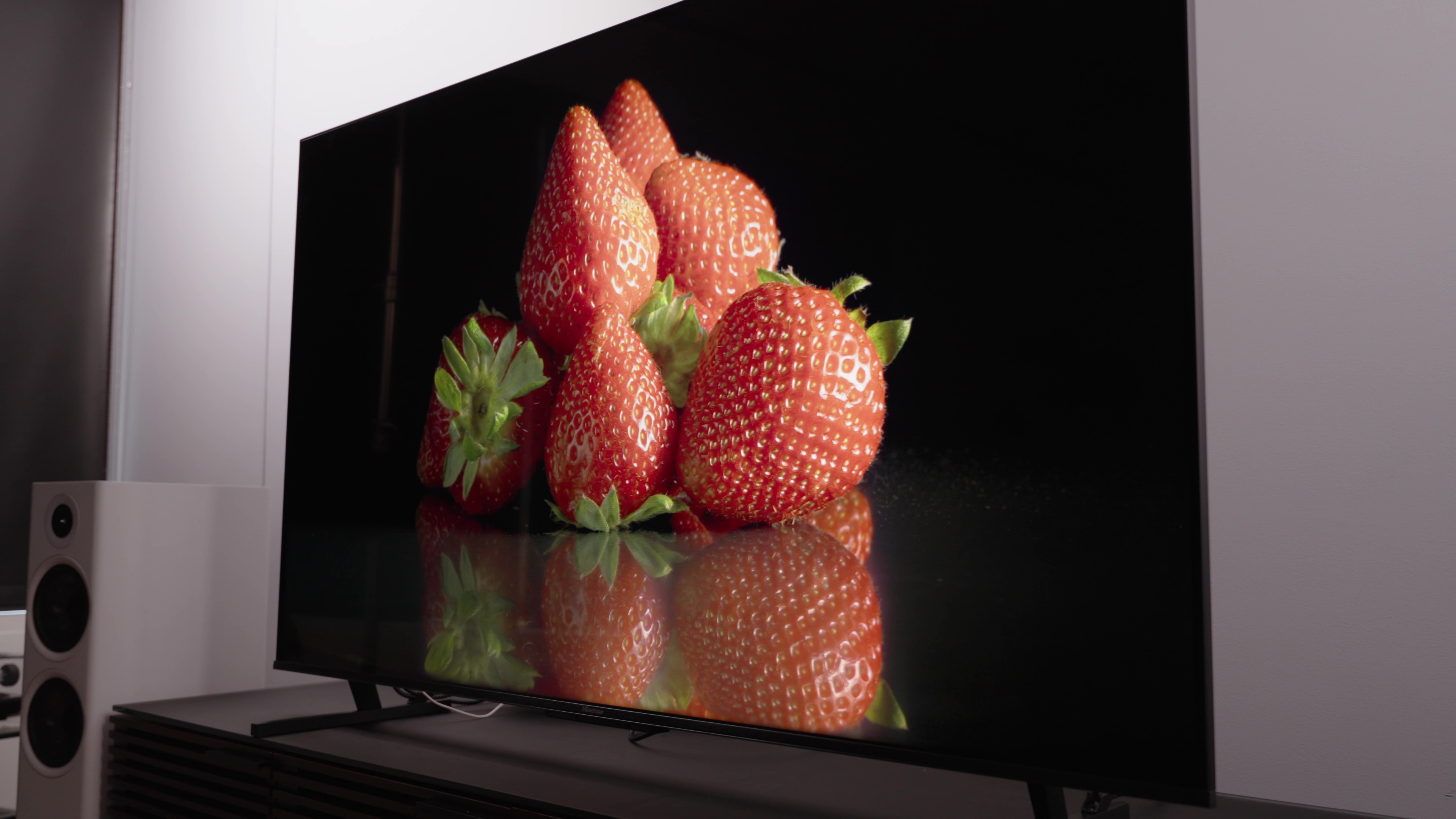 Uma pilha de morangos vermelhos maduros exibidos em uma TV Hisense U8K. 