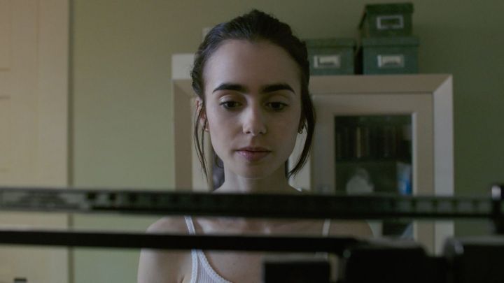 Lily Collins as Ellen in front of a scale in the movie To the Bone.