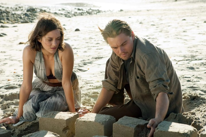 Marion Cotillard and Leonardo DiCaprio sit on a beach together in Inception.