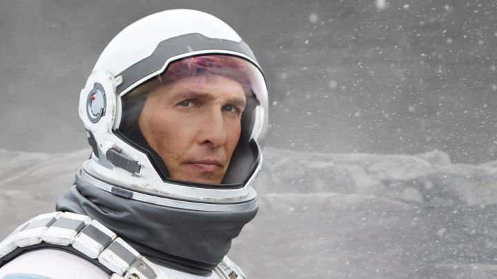Matthew McConaughey como Cooper em seu traje de astronauta olhando para longe em Interestelar.