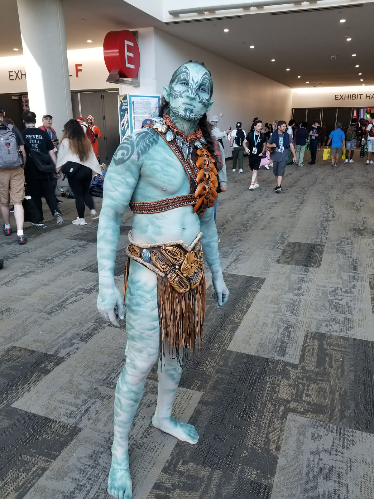 Um fã vestido como um guerreiro Na'vi de Avatar: The Way of Water.