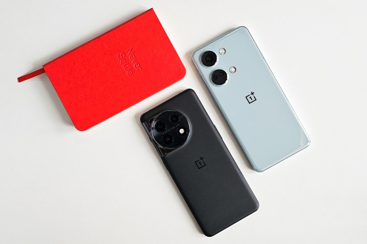 OnePlus Nord 3 Misty Green and OnePlus 11 Titan Black with a red Never Settle notebook.