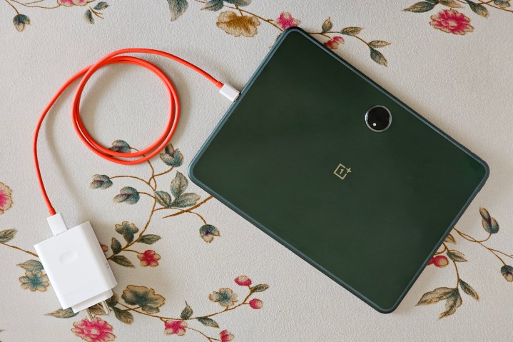 Cavo rosso OnePlus dal caricabatterie Super VOOC da 100 watt collegato al tablet Android OnePlus Pad verde.