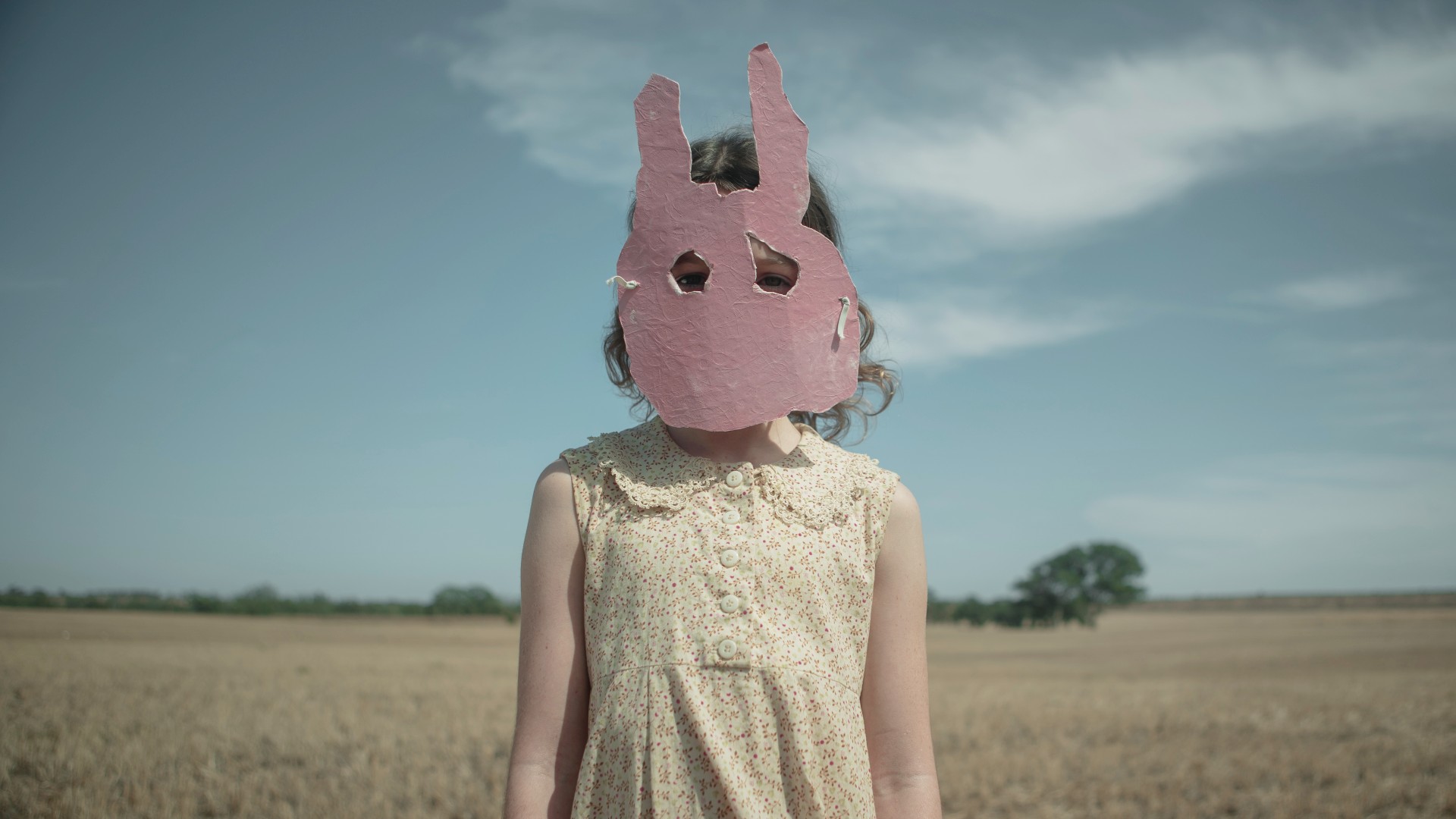 A girl wearing a rabbit mask stands in Run Rabbit Run.