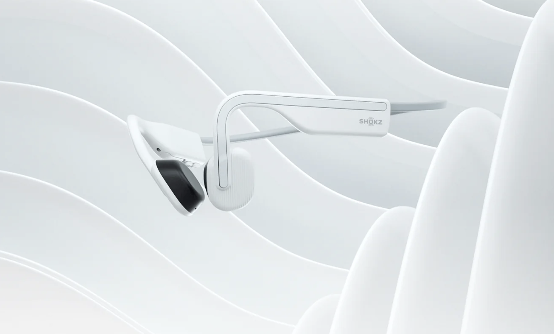 The Shokz OpenMove bone conduction headphones on a patterned background.