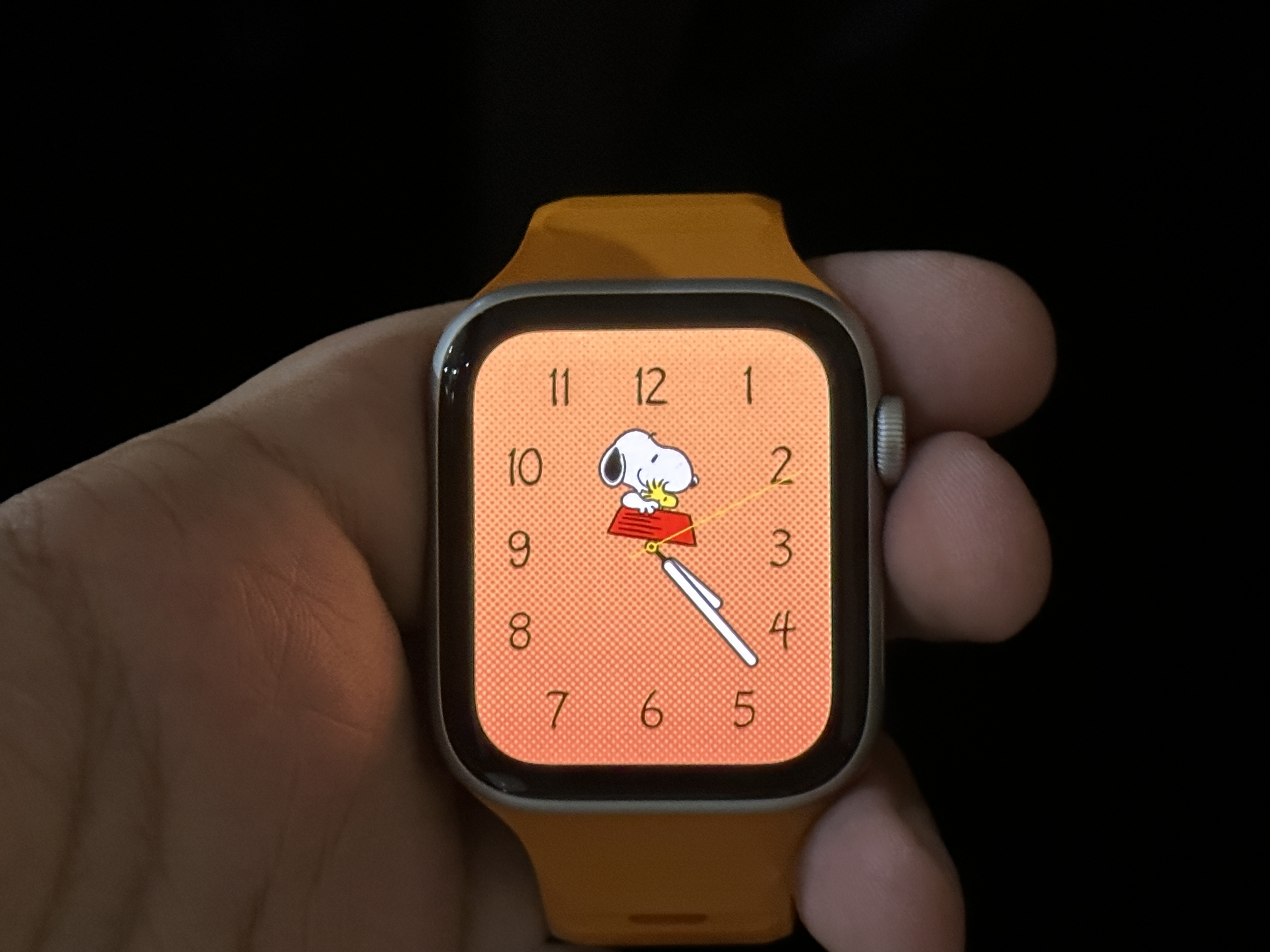 Snoopy Watch Face with Pumpkin background on Apple Watch SE.