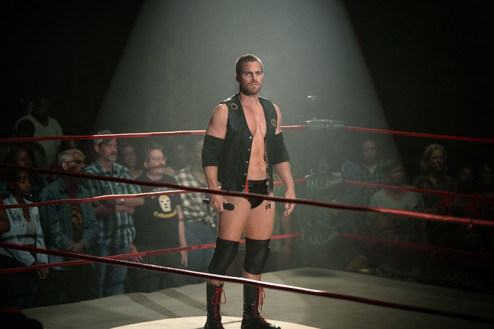 Stephen Amell stands in the center of a wrestling ring in Heels.