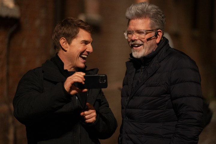 Tom Cruise and Christopher McQuarrie laugh together on the set of Mission: Impossible - Dead Reckoning Part One.