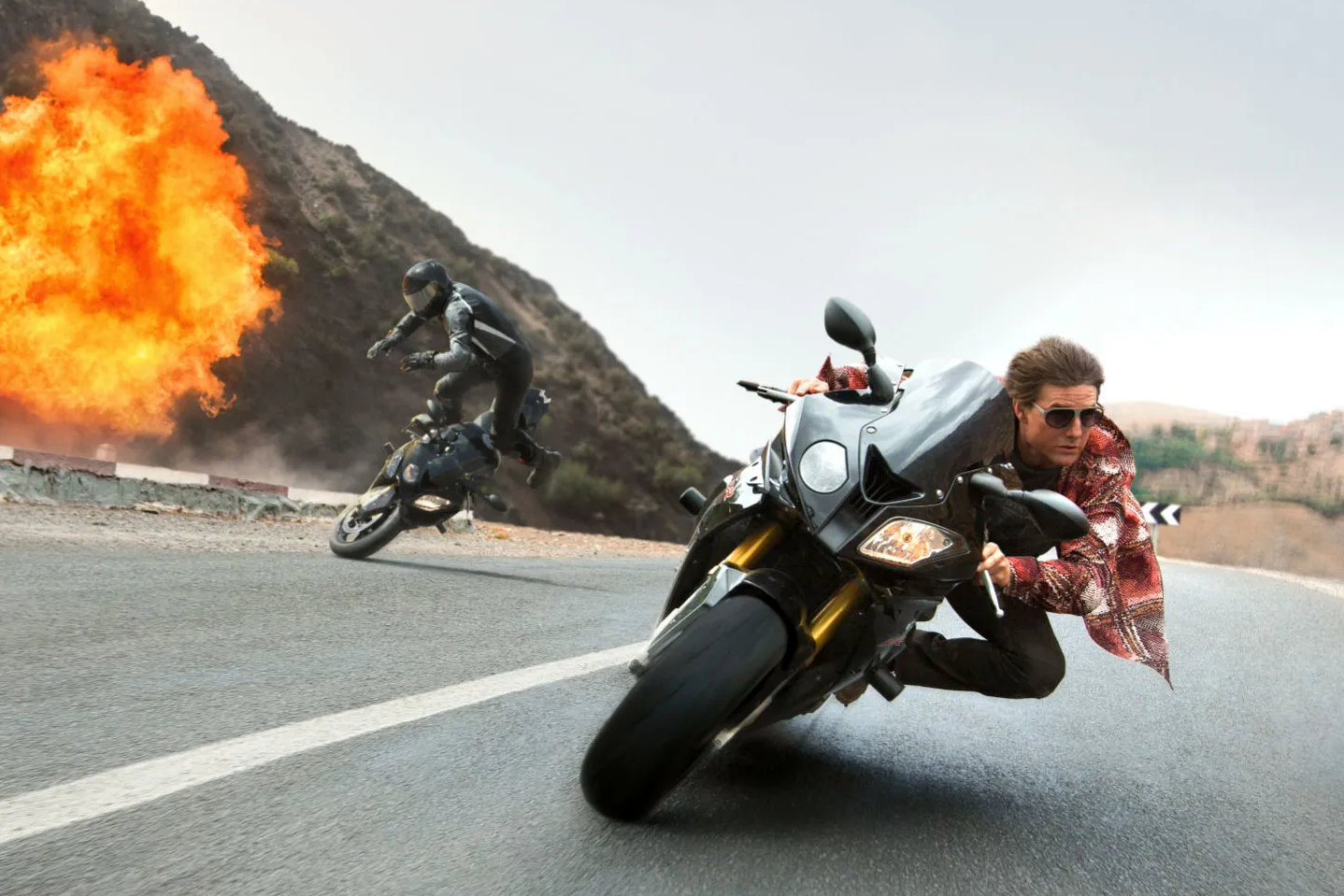 Tom Cruise dirige uma motocicleta em Missão: Impossível - Nação Secreta.