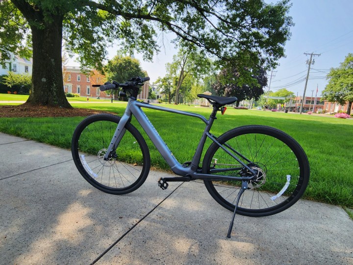 Lado esquerdo da bicicleta elétrica Velotric T1 com uma cidade verde da Nova Inglaterra ao fundo