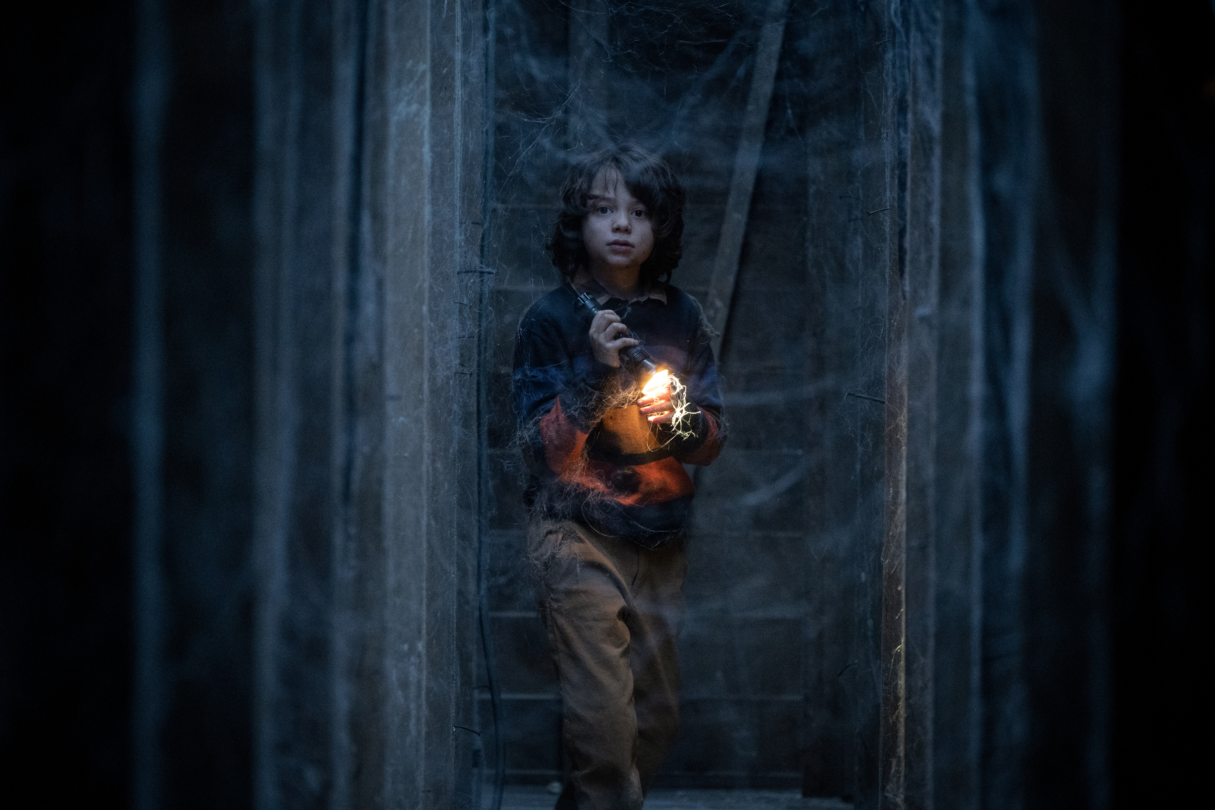 Woody Norman segura uma lanterna em um forro escuro em Cobweb.