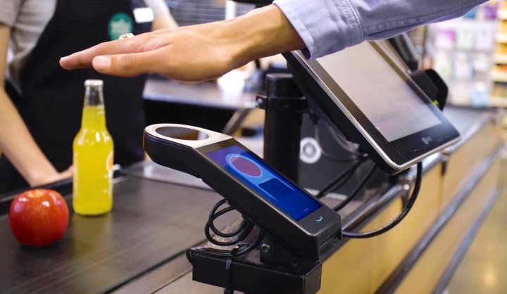 A person using their palm to pay at a Whole Foods Market store.