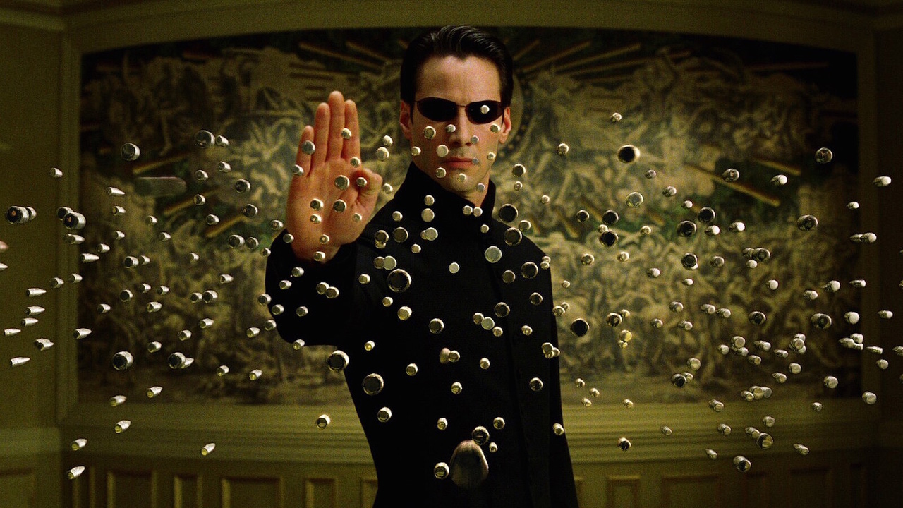 Keanu Reeves como Neo parando dezenas de balas em The Matrix Reloaded.