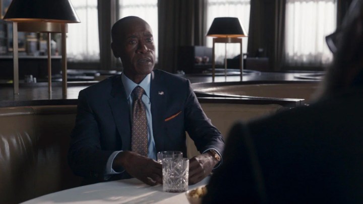 Rhodey sitting at a table in a suit in Secret Invasion. 