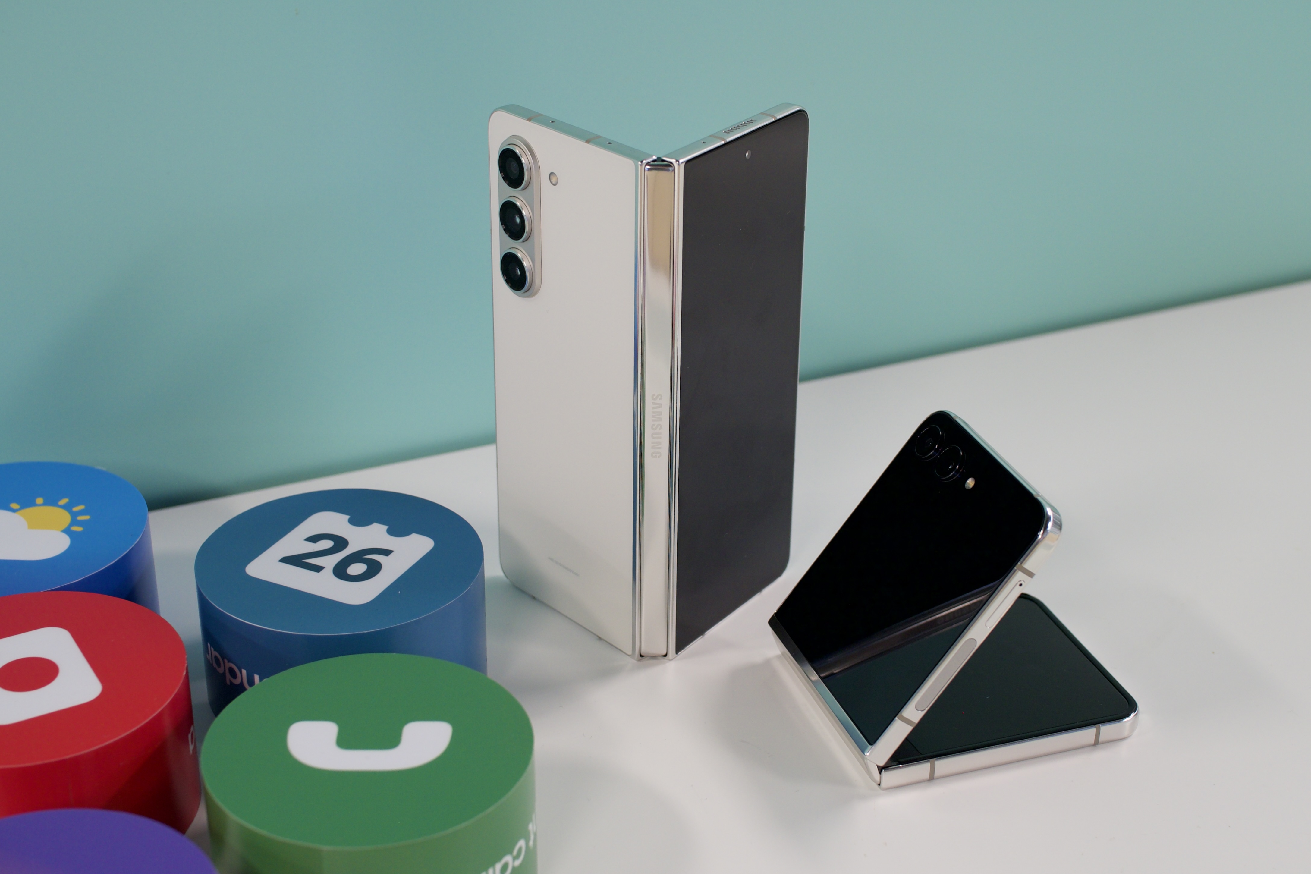 Samsung Galaxy Z Fold 5 و Galaxy Z Flip 5 کنار هم روی یک میز سفید رنگ.