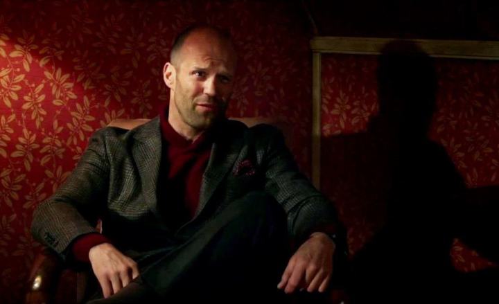 Jason Statham sits in a chair in Spy (2015).