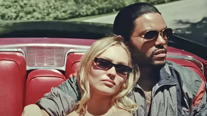Lily-Rose Depp and The Weeknd canoodling in a car in a scene from The Idol.