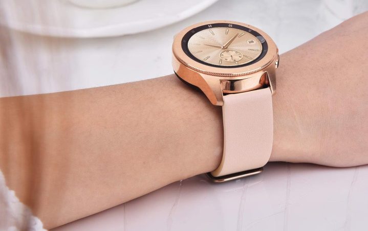 A pink leather strap by V-MORO on a traditional watch worn by a woman.
