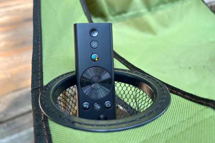 The Xgimi MoGo 2 Pro's Android TV Bluetooth remote in the cup holder of a deck chair.