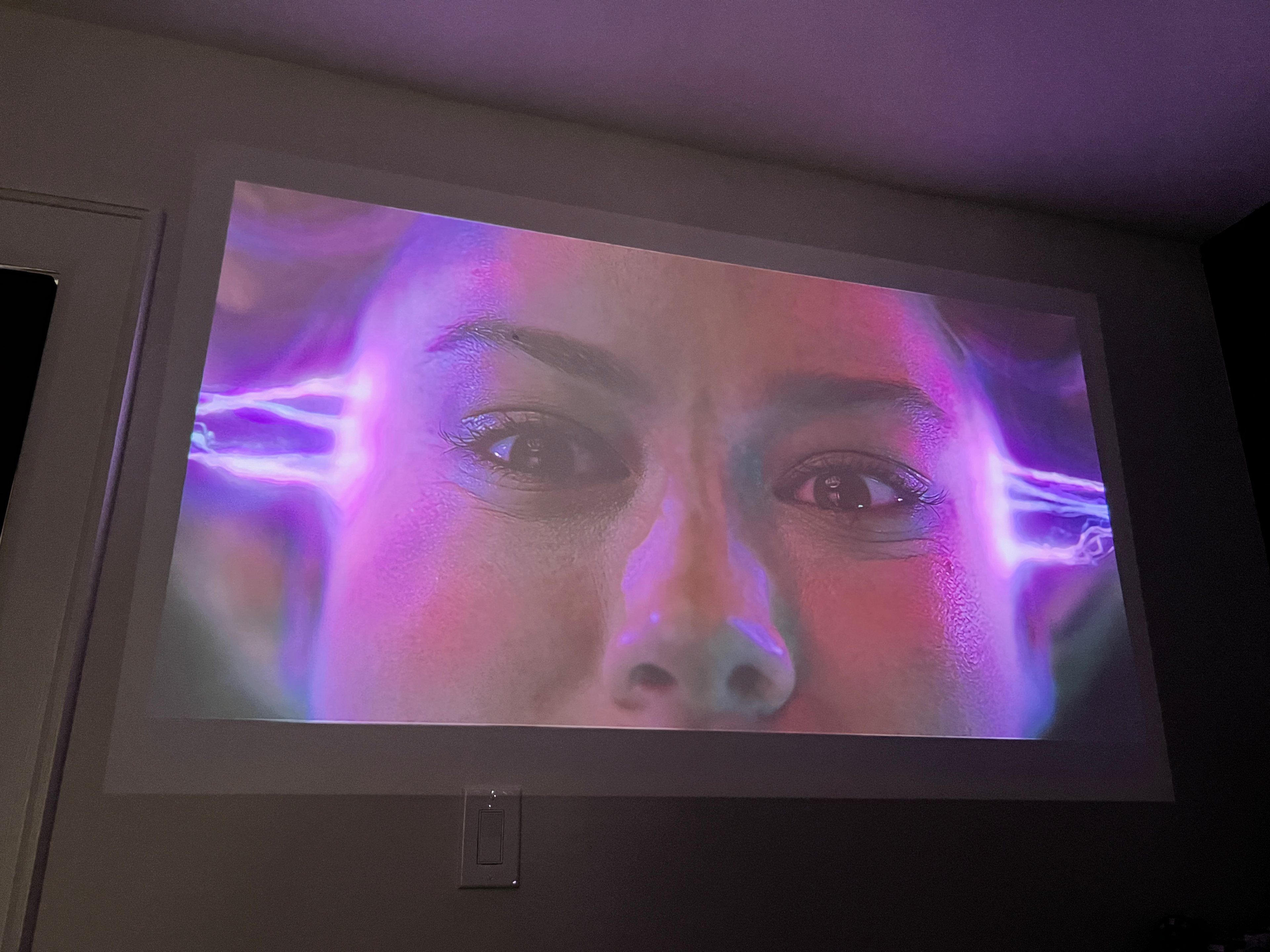 A imagem do Xgimi Mo-Go 2 Pro com a Capitã Marvel em uma sala com alguma luz ambiente.