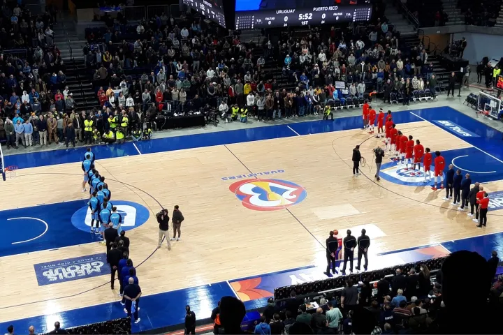 Los jugadores de baloncesto se paran en lados opuestos de la cancha.