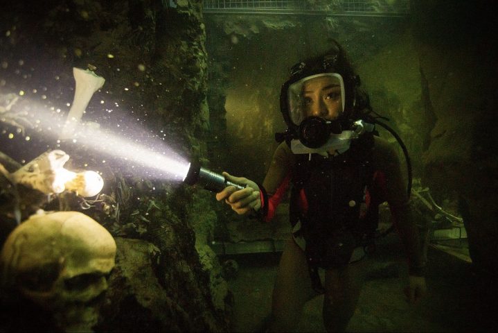 A scuba diver shines a flashlight in 47 Meters Down: Uncaged.