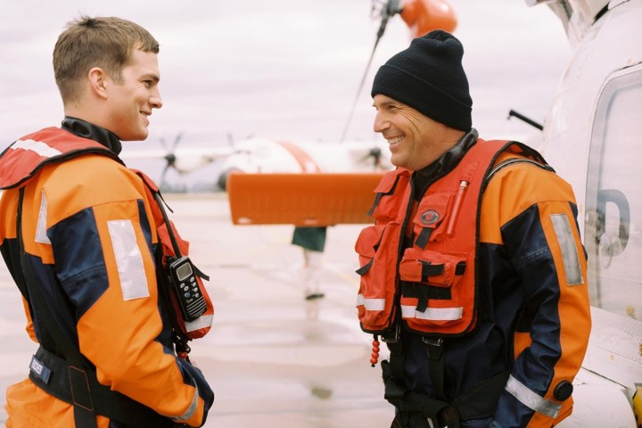 Two coast guard swimmers stand in front of each other and converse in The Guardian.
