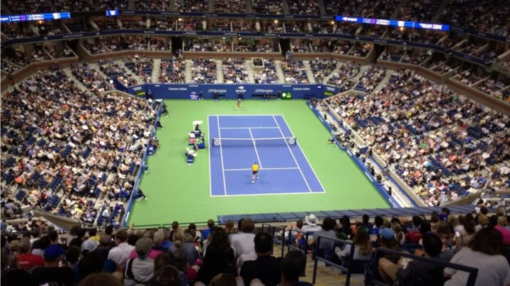 La gente se sienta en las gradas del estadio Arthur Ashe.