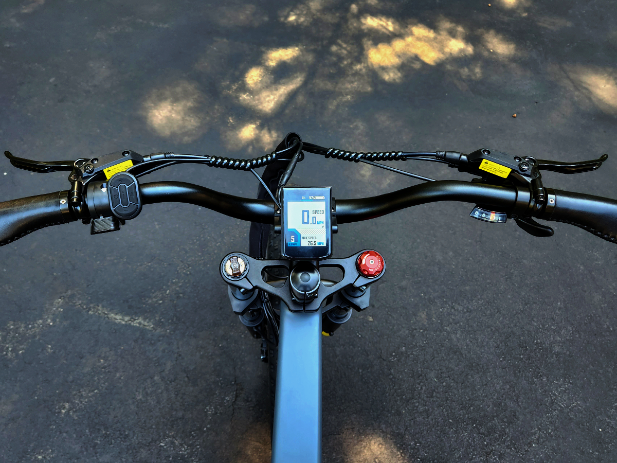 Engwe X24 handlebar with rider controls including display shifters, hydraulic brakes, bell, and thumb throttle.