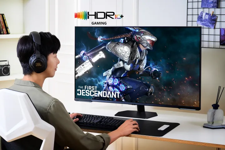 Мужчина сидит за столом и играет в The First Descendant. Мужчина использует монитор Samsung Odyssey Neo G9.