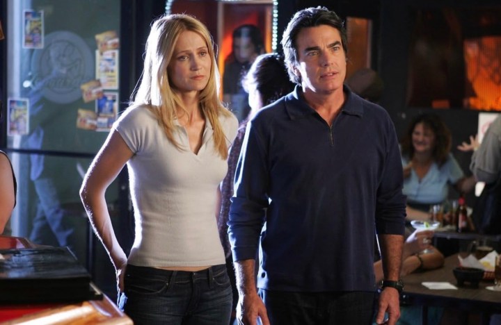 Kelly Rowan and Peter Gallagher stand next to each other in The O.C.