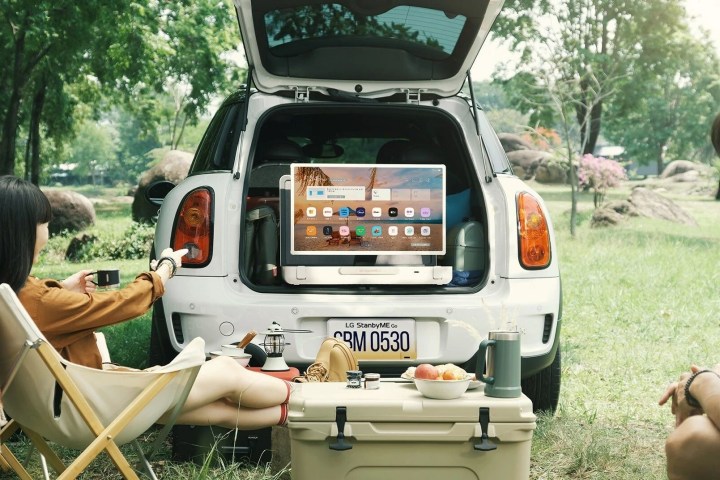 LG StanbyMe Go 27-inch touchscreen suitcase TV set up in the tailgate of a car.