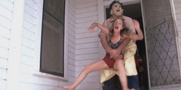 Leatherface grabs a victim and pulls her inside
