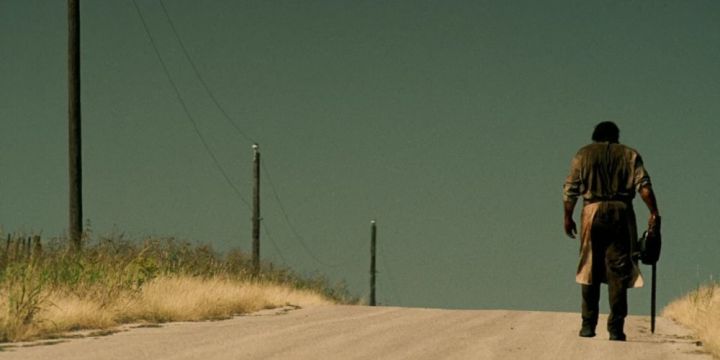 Leatherface walks down a barren road in Texas