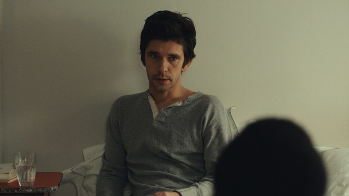 Ben Whishaw looks contemplative sitting in bed.