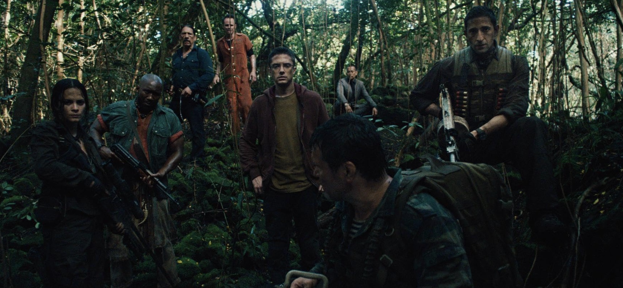 Um grupo de caçadores se une e segura armas na selva em Predators.