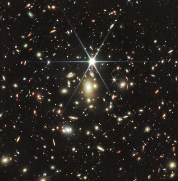 Esta imagen del Telescopio Espacial James Webb de la NASA de un cúmulo masivo de galaxias llamado WHL0137-08 contiene la galaxia más fuertemente ampliada conocida en los primeros mil millones de años del universo: el Arco del Amanecer, y dentro de esa galaxia, la estrella más distante jamás detectada. La estrella, apodada Earendel, fue descubierta por primera vez por el Telescopio Espacial Hubble. Las observaciones de seguimiento utilizando la NIRCam (Cámara de Infrarrojo Cercano) de Webb revelan que la estrella es una estrella masiva de tipo B más del doble de caliente que nuestro Sol, y aproximadamente un millón de veces más luminosa.