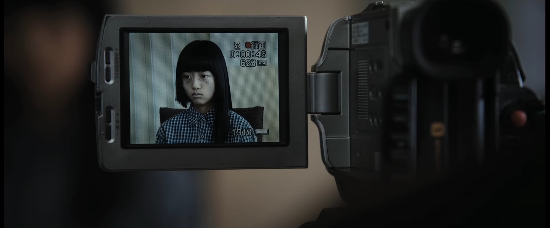 Uma garotinha sendo filmada por uma câmera de vídeo em "Silenced" (2011).