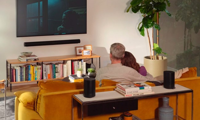 A couple watches TV with a Sonos surround set with Arc wireless soundbar set up.