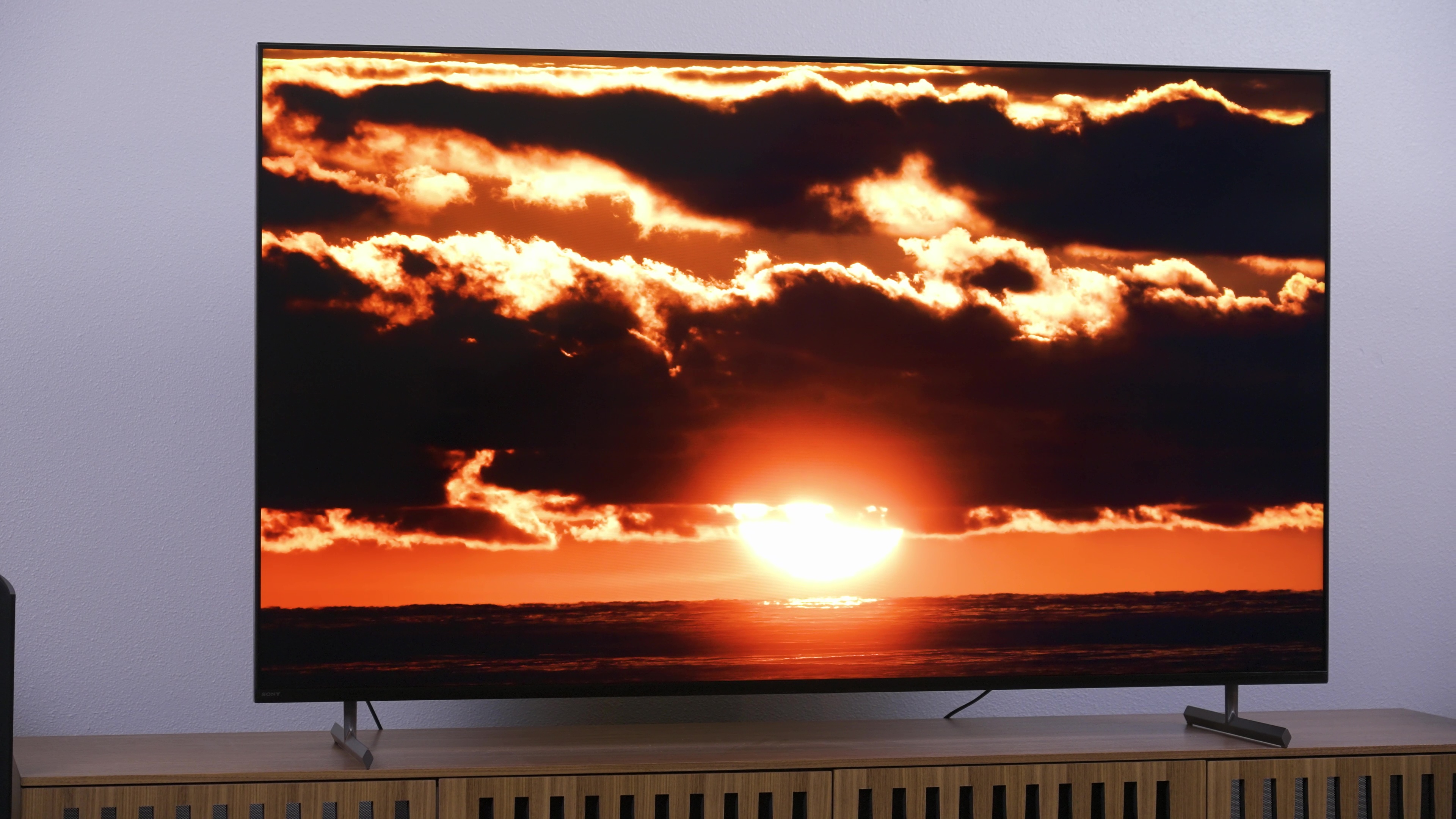 Sony X90L पर काले बादलों के बीच नारंगी सूर्यास्त प्रदर्शित किया गया।