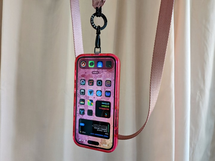 An iPhone 14 Pro hanging on Casetify's Utility Crossbody Lanyard strap.