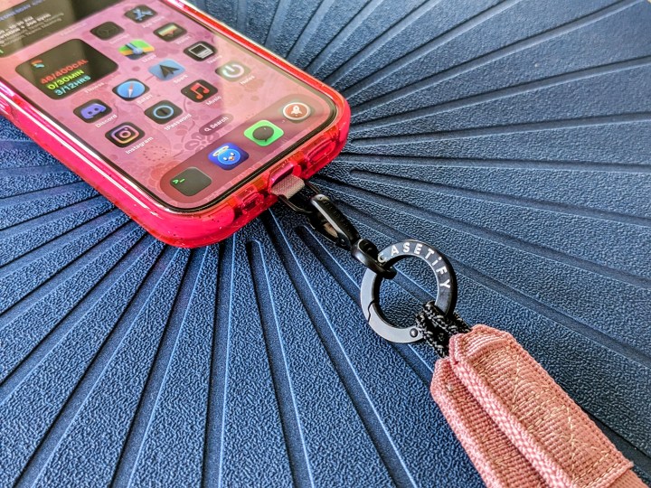 Casetify's Utility Crossbody Lanyard strap attached to the strap card in iPhone 14 Pro with case on.
