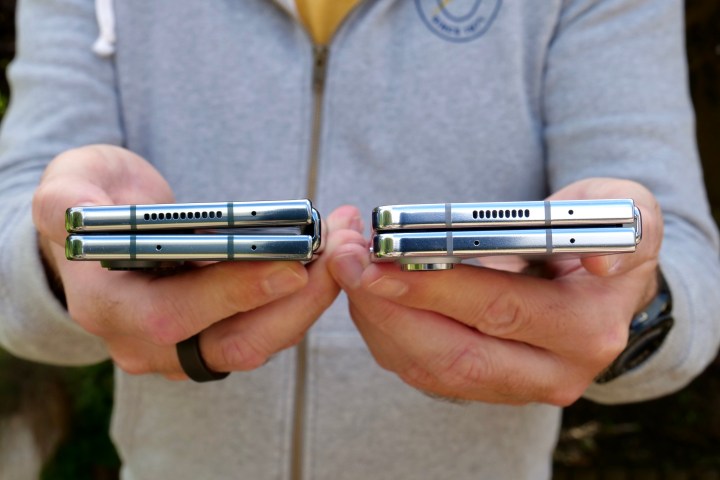 Человек держит Samsung Galaxy Z Fold 5 и Galaxy Z Fold 4, показывая застежку без зазора.