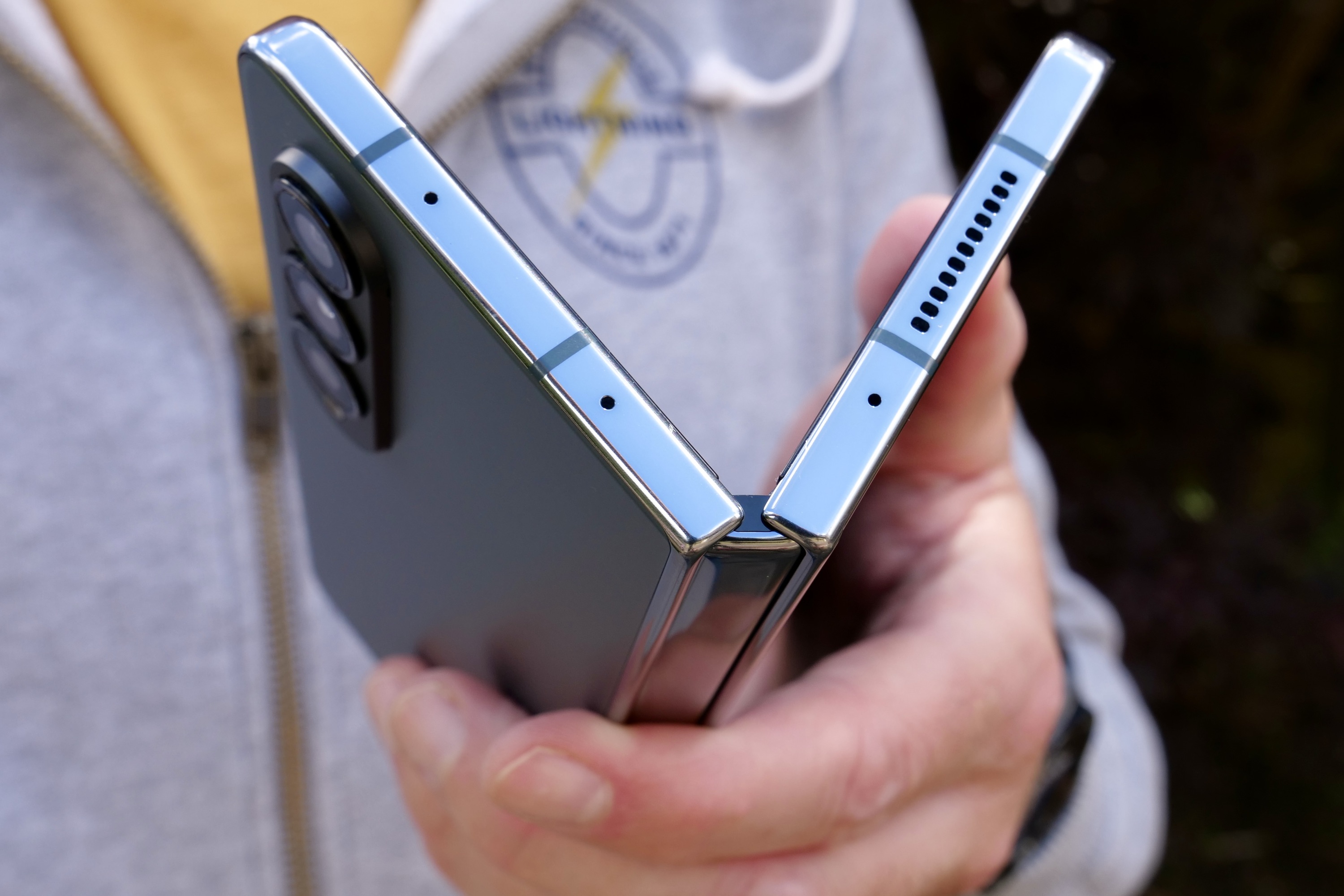 A person holding the Samsung Galaxy Z Fold 4, showing the top of the hinge.