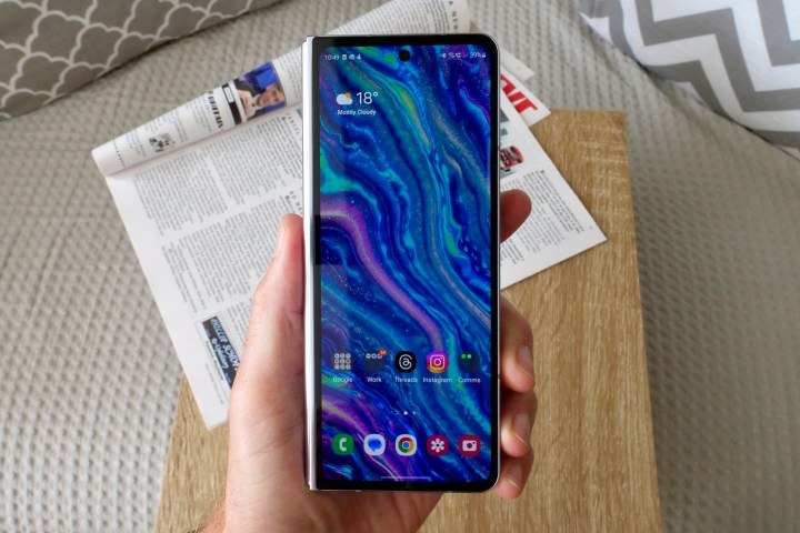 Kapak ekranını gösteren, Samsung Galaxy Z Fold 5'i tutan bir kişi.