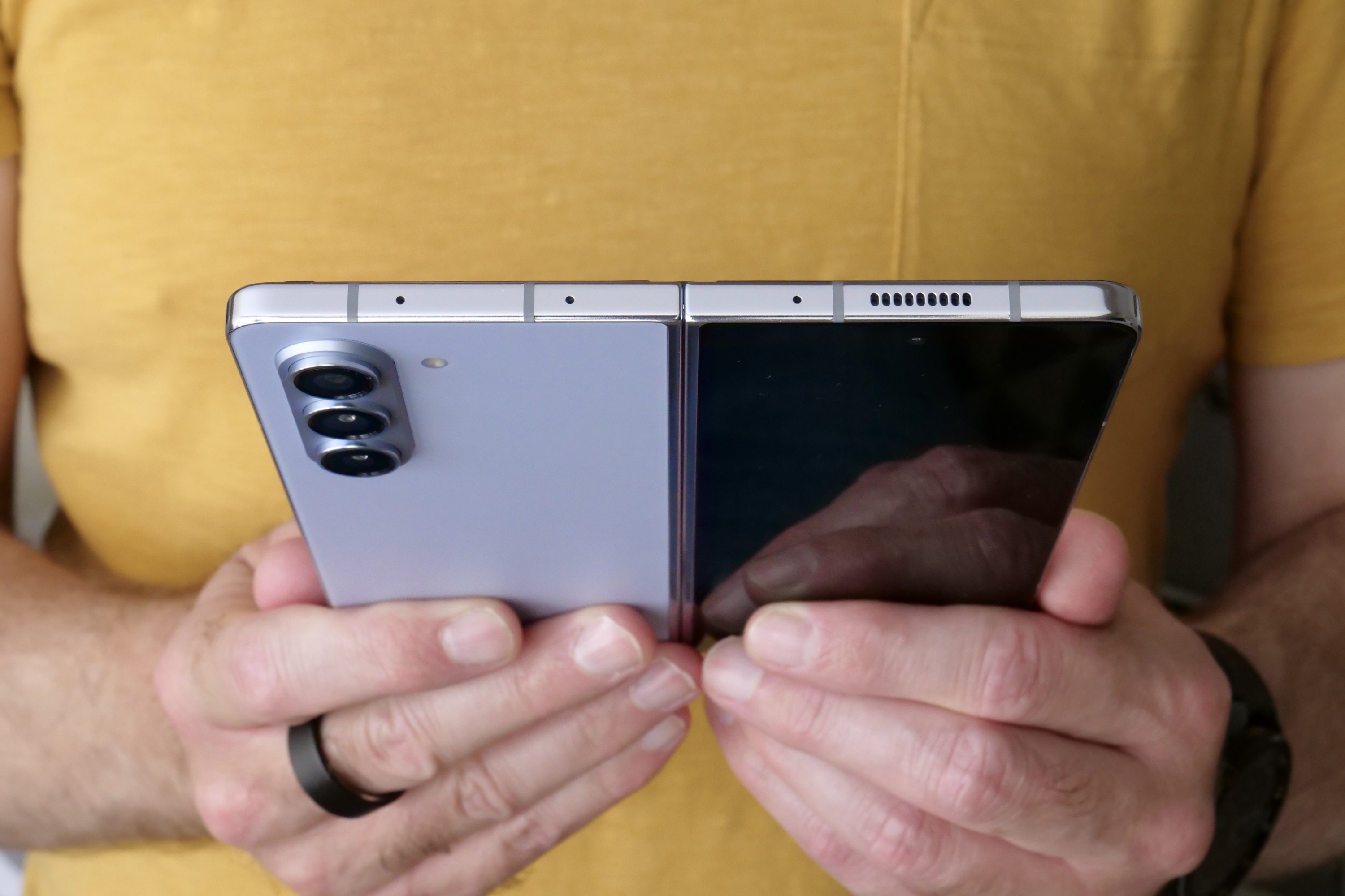 A person holding the open Samsung Galaxy Z Fold 5.